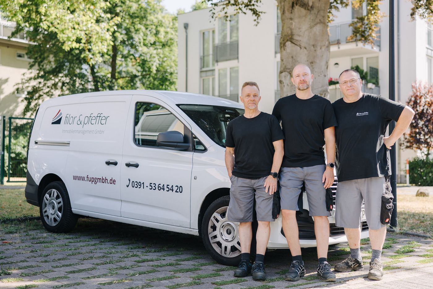 Hauswart-Team von Filor & Pfeffer mit Servicefahrzeug vor einer Wohnanlage